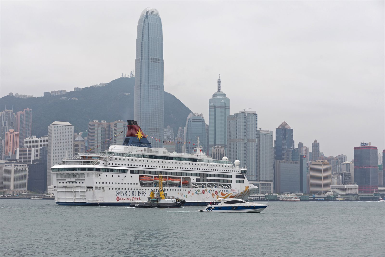 Hong Kong skyline and Victoria Harbour with a cruise ship and ferries, the kind of city covered in travel agent certification online courses