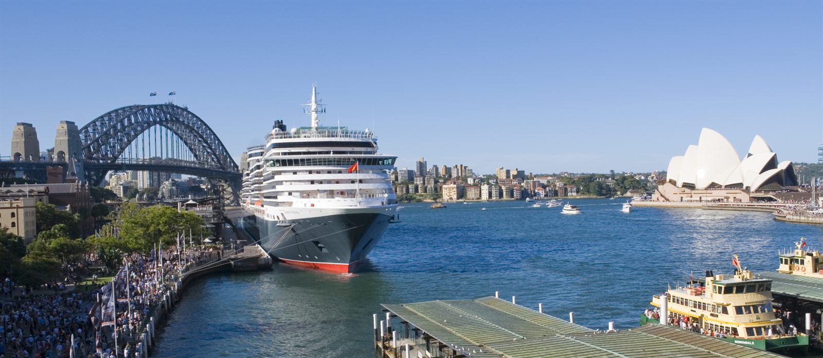Sydney Harbour with the Harbour Bridge, the Opera House and a ship at the quay, a scene every Aussie destination specialist learns